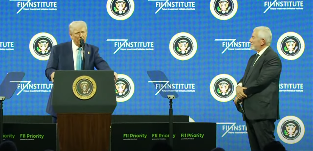 President Donald Trump speaking at the FII Summit in Miami, standing behind a podium with the presidential seal, addressing global investors and policymakers.